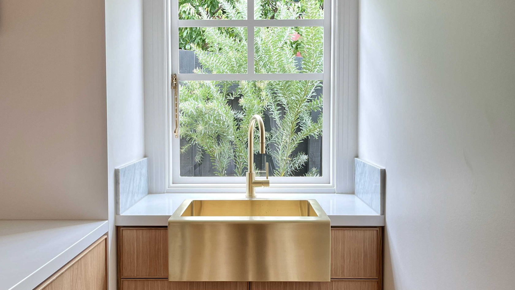 Luxury Timber Kitchen Cabinetry with Marble Benchtop Brass Sink window looking out to garden