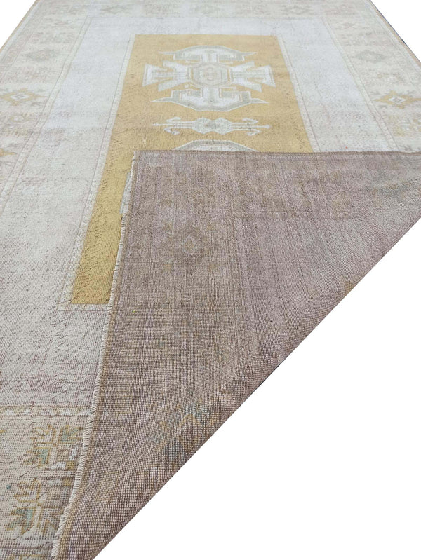 Vintage Handmade Turkish Rug with muted yellow tones and pale blue accents throughout the traditional border pattern.  Dated from the 1960's.  Traditional Vintage Turkish Rug available in Melbourne 